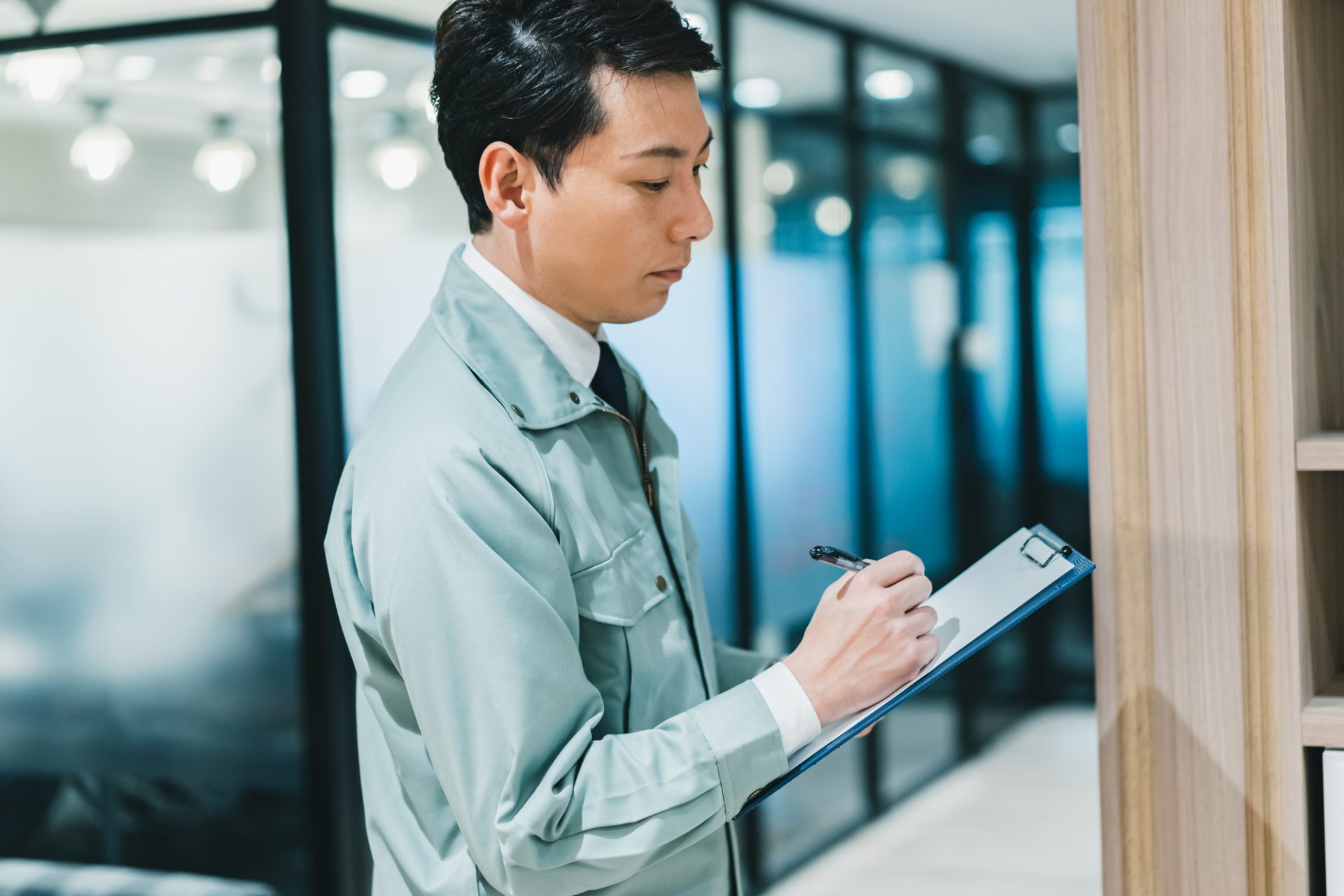 作業着を着てオフィスを点検する男性