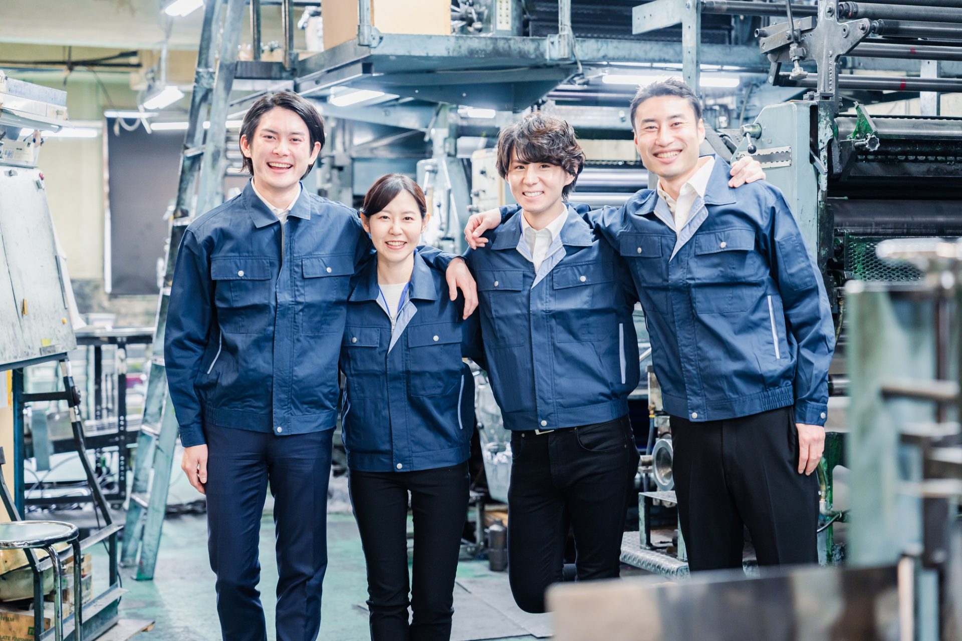 仲良く肩を組む工場スタッフ