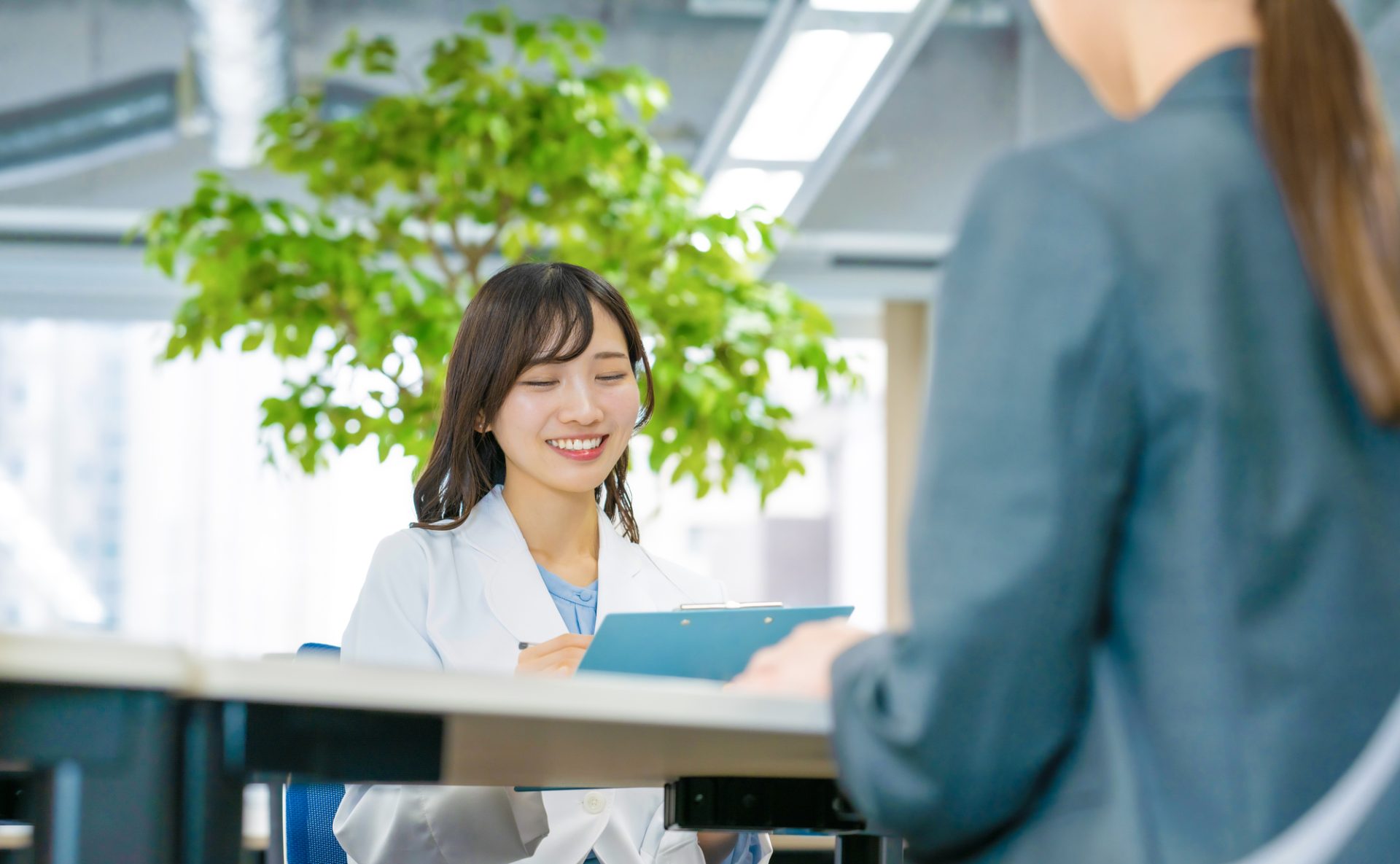 オフィスで面談をしている女医と従業員