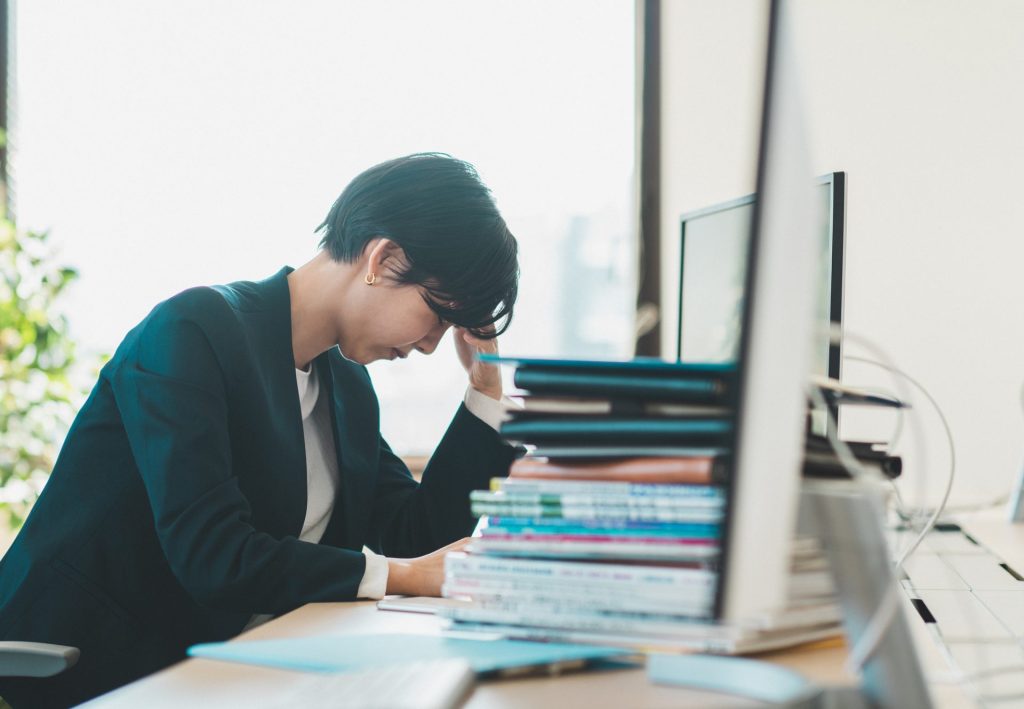 疲労がたまる中で勤務するビジネスパーソンのイメージ